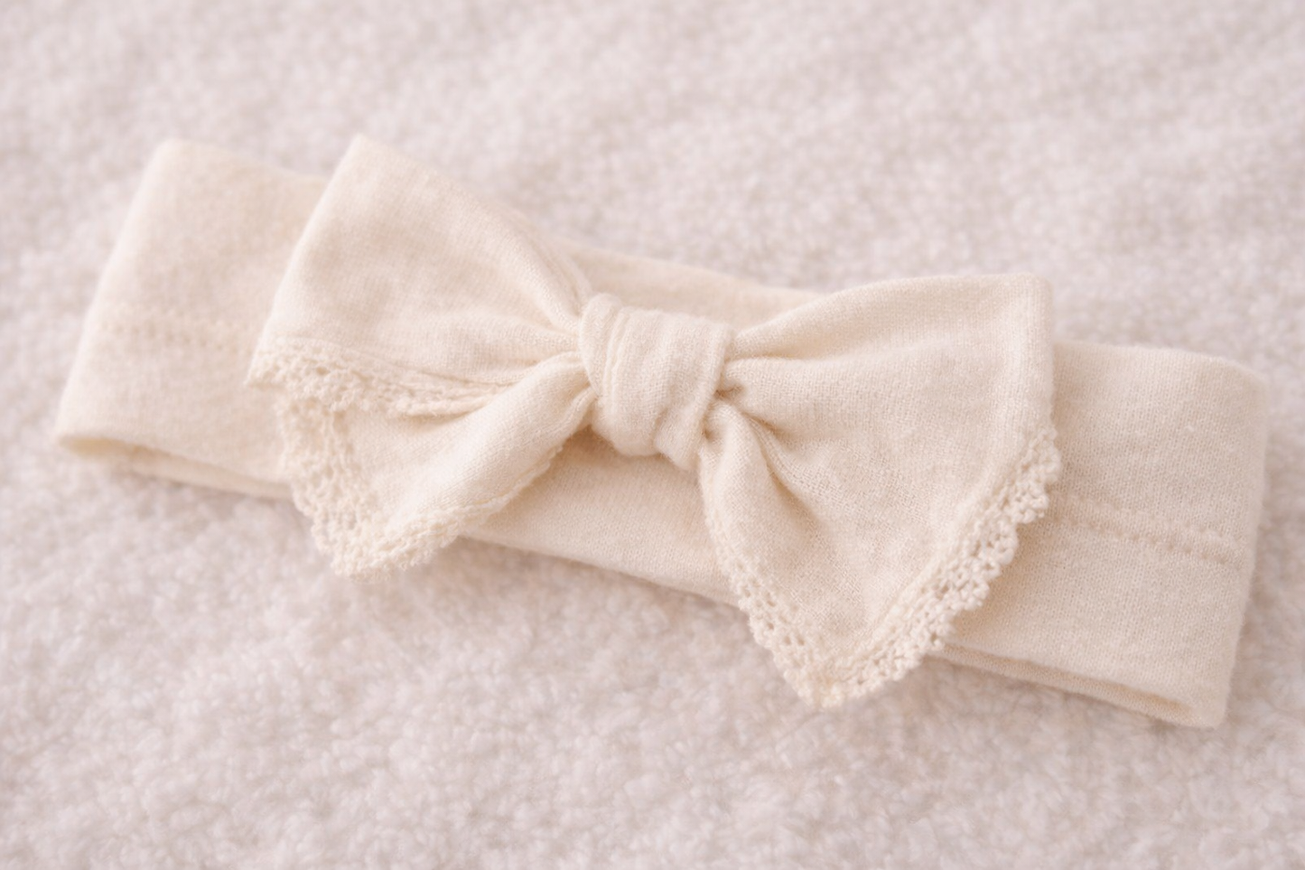 Neugeborenes trägt Bio Newborn Set aus Baumwolle – nachhaltige Babykleidung in Creme